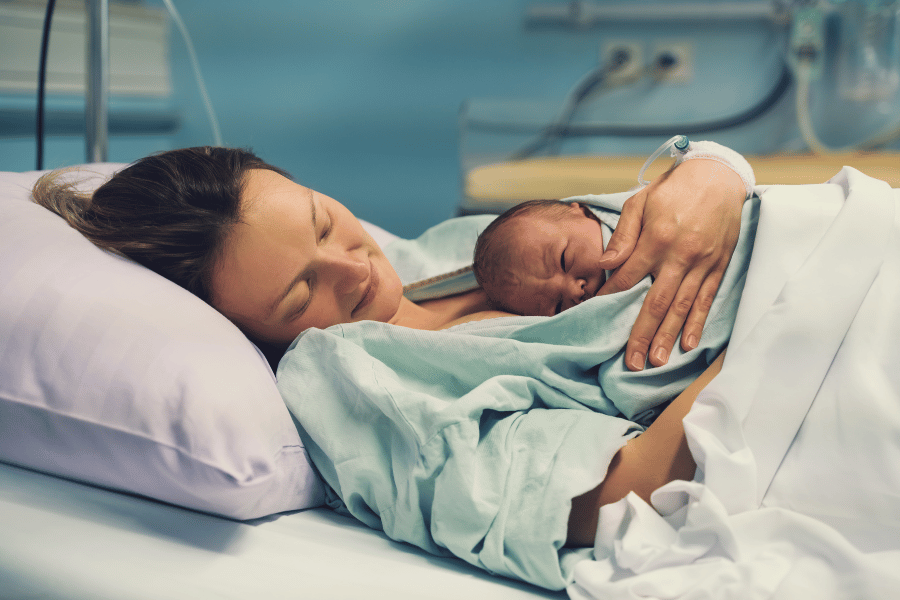 Woman holding baby in hospital bed