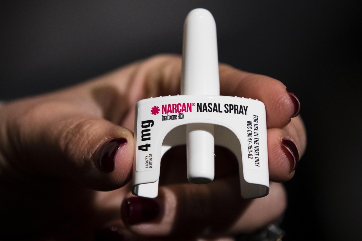 a hand holding a narcan nasal spray